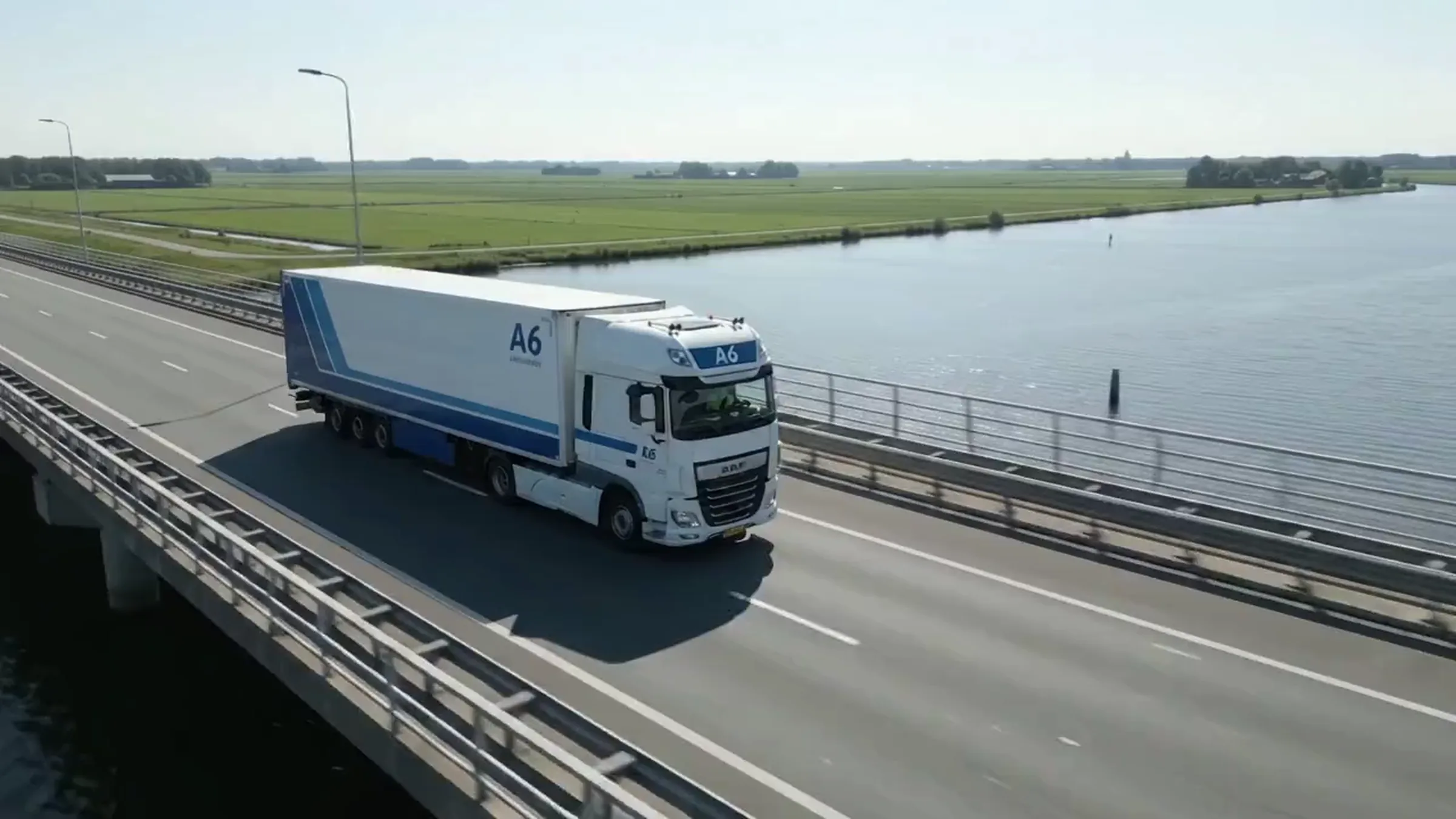 Vrachtwagen op een dijkweg langs het water
